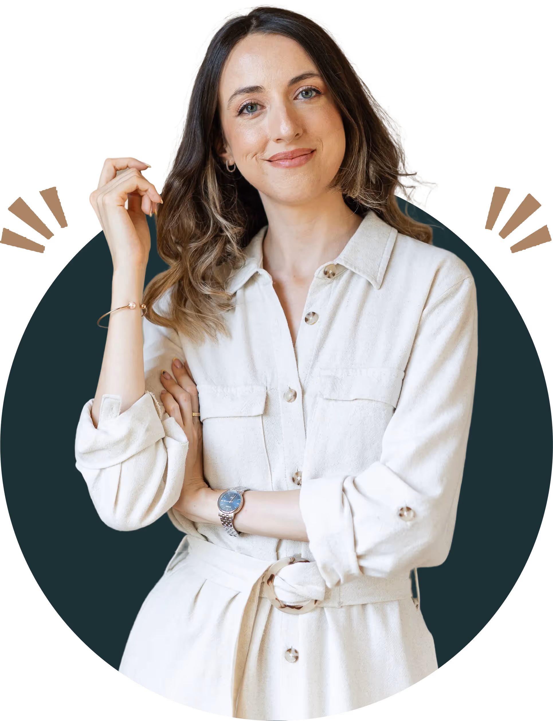 Smiling woman with wavy hair, wearing a cream button-up dress with rolled sleeves and a watch, posing with crossed arms.