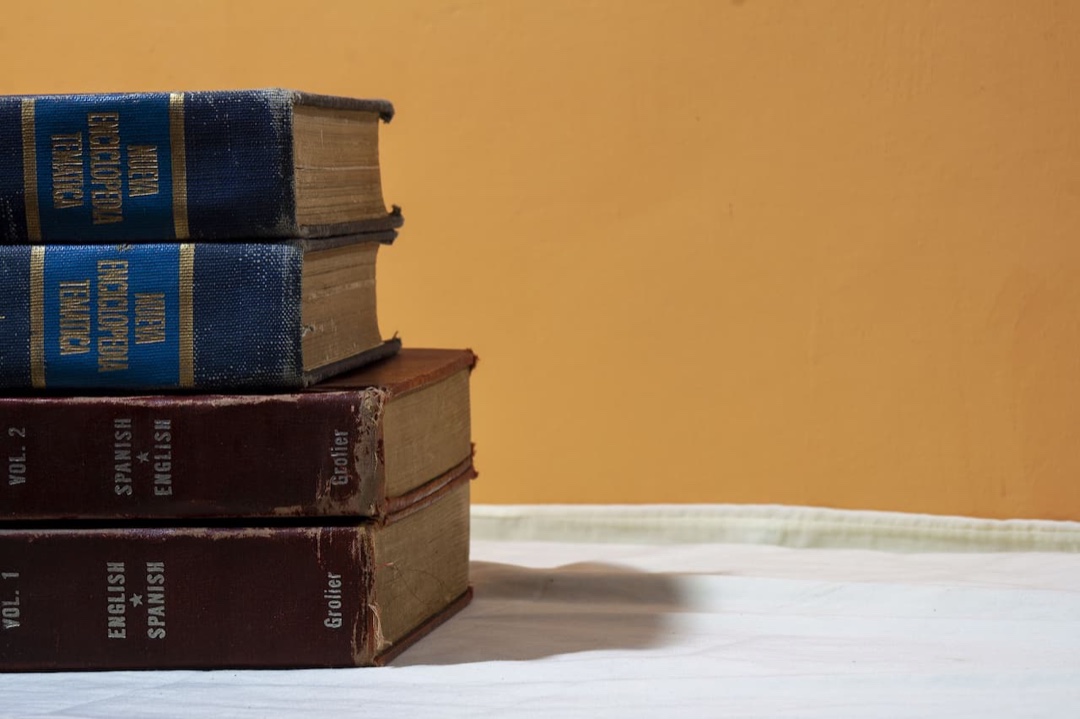 Una pila de viejos diccionarios de inglés y español sobre una mesa